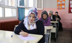 Kitap okuma yarışmasına katılan anneler çocuklarının oturduğu sıralarda sınava girdi